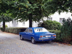 Ein blauer Opel Rekord C am Straßenrand