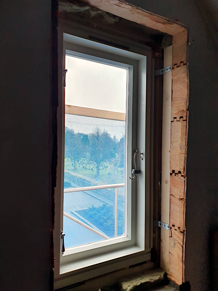 Blick auf ein frisch eingebautes Fenster in einem alten Holzhaus in Stavanger