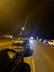 Geparkte Fahrzeuge am Straßenrand im Dunkeln